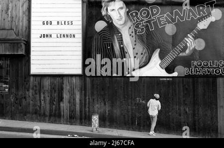 Firma che commemora la morte di John Lennon nel 1980 accanto a un cartellone per Rod Stewart sul lato del negozio di dischi di liquirizia Pizza sulla Sunset Strip. Foto Stock