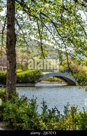 Dilijan, Armenia - 26 aprile 2022 - piccolo ponte che attraversa il laghetto nel parco della città di Dilijan Foto Stock