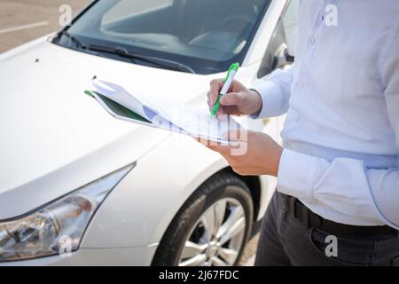 un uomo firma i contratti sulla strada in primo piano. Foto Stock