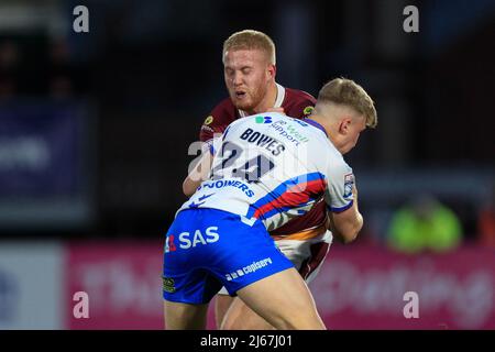 Oliver Wilson (20) di Huddersfield Giants è affrontato da Harry Bowes (24) di Wakefield Trinity Foto Stock