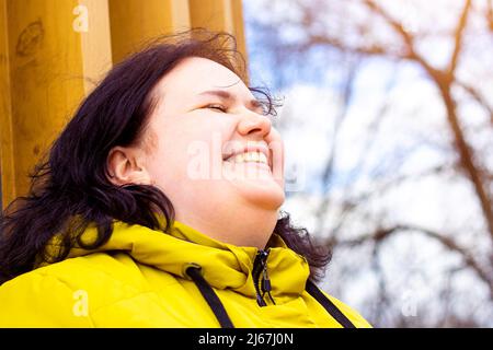 Felice attraente chubby sovrappeso donna caucasica sorridente ritratto all'aperto. Un bel corpo allegro, persona positiva che ride durante la passeggiata nel parco. Foto Stock