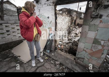 Irpin, Ucraina. 28th Apr 2022. Natalia Tsyukalo, 62, dimostra come si nascose nella sua cantina dalla sgranatura russa che ha colpito gli appartamenti di fronte alla sua casa a Irpin, Ucraina 27 aprile 2022. Gli Stati Uniti hanno prove credibili delle truppe russe che hanno eseguito ucraini in consegna nella regione di Donetsk, un funzionario degli Stati Uniti ha detto agli stati membri delle Nazioni Unite che cercano di tenere i responsabili per i crimini di guerra commessi dalla Russia di rendere conto. Credit: UPI/Alamy Live News Foto Stock