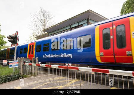Un treno ferroviario sud-occidentale che passa a livello di Vine Road attraversando la scatola di segnalazione, Barnes, Londra, SW13, Inghilterra, REGNO UNITO Foto Stock