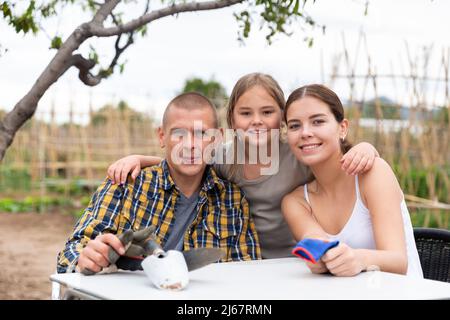 La famiglia era cordiale e si sedeva al tavolo dopo aver lavorato in un orto Foto Stock