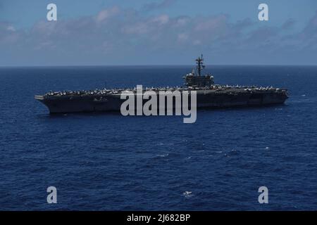 MARE DELLE FILIPPINE (26 aprile 2022) la portaerei di classe Nimitz USS Abraham Lincoln (CVN 72) transita nel Mare delle Filippine. Abraham Lincoln Strike Group è in fase di implementazione pianificata nell'area delle operazioni della flotta USA 7th per migliorare l'interoperabilità attraverso alleanze e partnership, fungendo da forza di risposta pronta a supportare una regione indopacifica libera e aperta. (STATI UNITI Foto Navy di Mass Communication Specialist 3rd Class Thaddeus Berry) Foto Stock