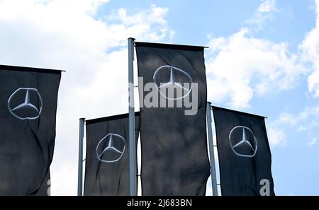 Stoccarda, Germania. 28th Apr 2022. 28 aprile 2022, Baden-Wuerttemberg, Stoccarda: Bandiere con il logo del costruttore di automobili Mercedes-Benz stanno volando di fronte al museo del Gruppo. L'assemblea generale annuale del gruppo automobilistico si terrà il 29 aprile. Foto: Bernd Weißbrod/dpa Credit: dpa Picture Alliance/Alamy Live News Foto Stock