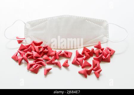 Origami rosso a forma di cuore e maschera facciale N95 su sfondo bianco - foto di scorta Foto Stock