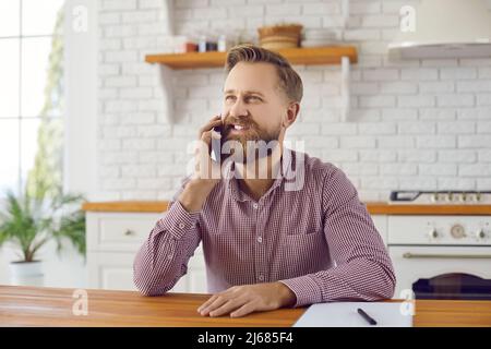 Un uomo sorridente parla di gadget per smartphone Foto Stock