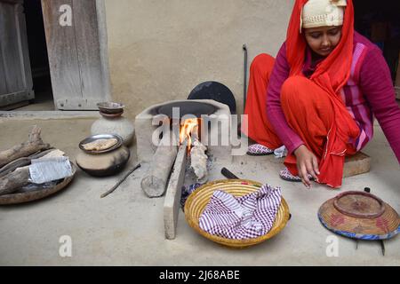 INDIA, UTTTAR PRADESH, dicembre 2021, una donna che fa chapati su tawa in una cucina indiana rurale, Chulha è una stufa di fango a forma di U fatta da argilla locale, em Foto Stock