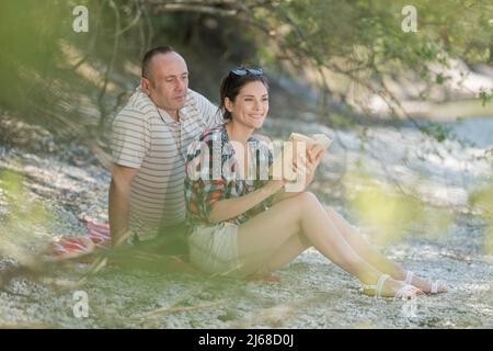 bella coppia matura felice abbraccia vicino al lago Foto Stock
