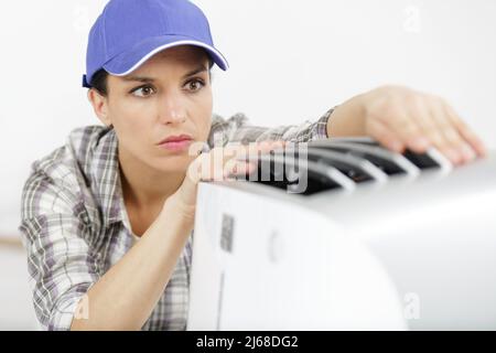 lavoratrice femminile nel lavoro generale di fissaggio tostapane in cucina Foto Stock