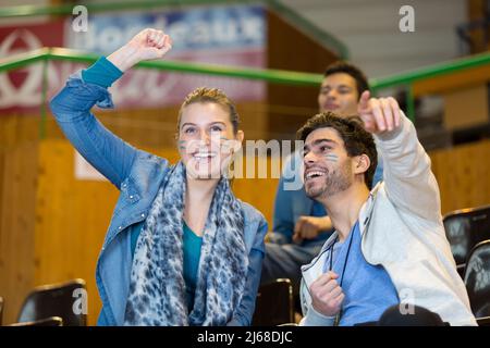 tifosi sportivi in piedi indossando facepaint Foto Stock