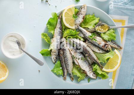 Sardine grigliate con limone e erbe vicino. Vegetariano sano farina di pesce Foto Stock