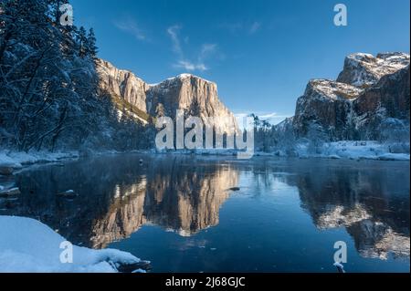 Impressione delle montagne che circondano la Valle di Yosemite, durante l'ora d'oro, che si riflettono nel fiume Merced. Foto Stock