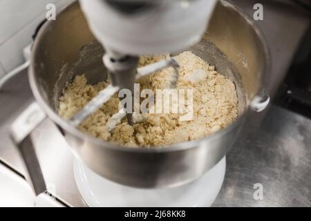 Vista ravvicinata di un mixer elettrico per preparare l'impasto in una ciotola. Foto Stock