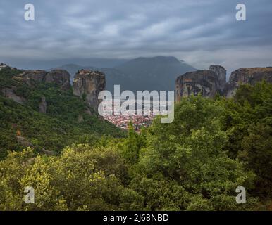 Città Kalampaka tra due rocce con la Santa Trinità monastero su una sommità, Meteora, Grecia Foto Stock