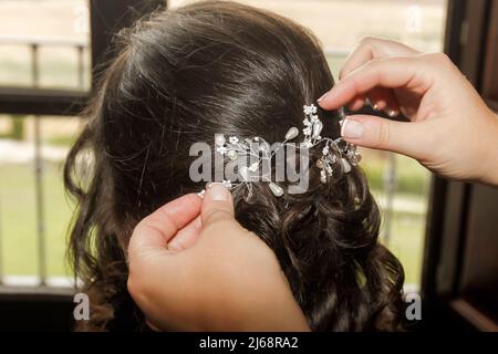 Ornamento dei capelli piacevole che è messo sulla testa di una donna con i capelli scuri. Foto Stock