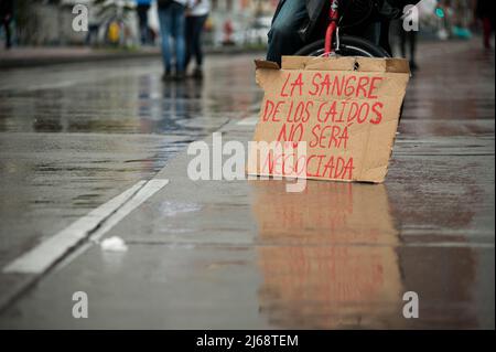 Un dimostratore ha un segno che recita 'il sangue da quelli caduti non sarà mai negoziato' durante le dimostrazioni commemorative del 28 aprile a. Foto Stock