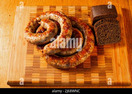salsicce alla griglia su un tagliere con pane Foto Stock