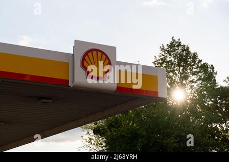 Stazione di servizio Royal Dutch Shell al tramonto. Grande logo sull'esterno di un edificio. Industria della benzina con un'attività nel settore dei trasporti e dell'energia. Foto Stock