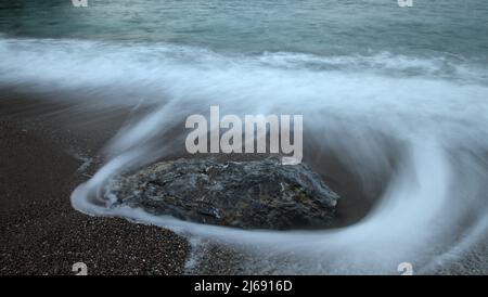 Bella esposizione lunga foto di mare seascape, serica onda di mare liscia che passa attraverso la roccia. Messa a fuoco morbida a causa di un'esposizione prolungata. Foto Stock