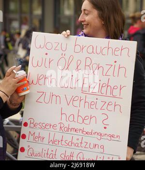 Magonza, Germania. 29th Apr 2022. 29 aprile 2022, Renania-Palatinato, Magonza: Un educatore cammina con un cartello che dice "che cosa abbiamo bisogno di petrolio e benzina per quando abbiamo educatori per bruciare?" Durante una dimostrazione da parte di autisti e educatori in autobus in una dimostrazione congiunta attraverso il centro di Mainz. Dopo che i conducenti dell'industria degli autobus privati erano andati in sciopero il giorno prima in Renania-Palatinato, le aziende erano anche principalmente ad una fermata il venerdì (29,04.). Gli educatori in sciopero allo stesso tempo si erano Uniti alla protesta. Foto: Frank Rumpenhorst/dpa Credit: dpa Picture Alliance/Alamy Live News Foto Stock