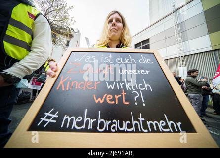 Magonza, Germania. 29th Apr 2022. 29 aprile 2022, Renania-Palatinato, Magonza: Un educatore cammina con un cartello che dice "Qual è il futuro dei nostri figli davvero vale per voi?" Durante una dimostrazione da parte di autisti e educatori in autobus in una dimostrazione congiunta attraverso il centro di Mainz. Dopo che i conducenti dell'industria degli autobus privati erano andati in sciopero in Renania-Palatinato il giorno prima, le aziende erano anche principalmente ad una fermata il venerdì (29,04.). Gli educatori in sciopero allo stesso tempo si erano Uniti alla protesta. Foto: Frank Rumpenhorst/dpa Credit: dpa picture Alliance/Alamy Live News Credit: dpa p Foto Stock