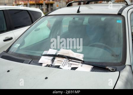 Wroclaw, Polonia - 27 Aprile 2022: Una pila di multa da parcheggio non retribuita sul parabrezza di un'auto abbandonata Foto Stock