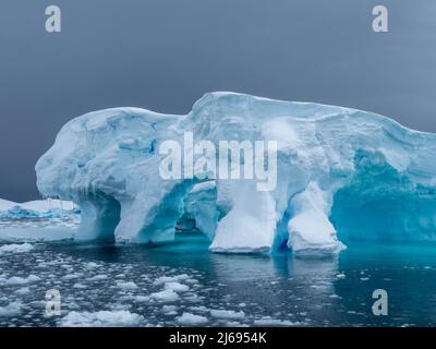 Un enorme iceberg si trova su una barriera corallina vicino al cimitero di Iceberg, all'isola di Pleneau, all'Antartide e alle regioni polari Foto Stock