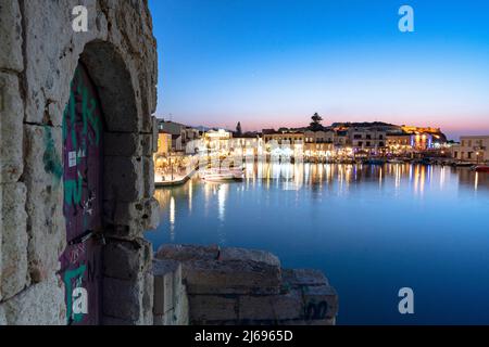 Luci del vecchio porto veneziano riflesse nel mare al crepuscolo, Rethymno, isola di Creta, Isole greche, Grecia, Europa Foto Stock