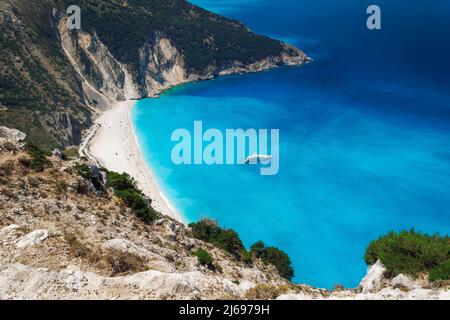 Vista panoramica della famosa spiaggia di Myrtos, con acque cristalline e yacht ormeggiato nell'isola di Cefalonia, Isole Greche, Grecia, Europa Foto Stock