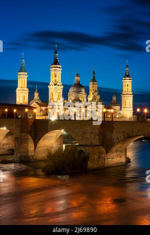 Basilica del Pilar Cattedrale con ponte di pietra che attraversa il fiume Ebro di notte, Saragozza, Aragona, Spagna, Europa Foto Stock