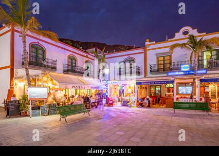 Vista di caffè e ristoranti a Puerto de Mogan e sfondo montuoso al tramonto, Puerto de Mogan, Gran Canaria, Isole Canarie, Spagna, Atlantico Foto Stock