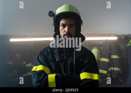 Giovane vigile del fuoco afroamericano di notte in una stazione dei vigili del fuoco. Foto Stock