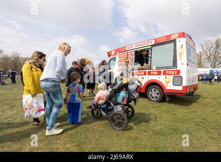 Ice cream van UK; una famiglia con bambini in fila per acquistare gelato da un uomo MR Whippy Ice Cream, in una giornata di sole in primavera, Suffolk UK Foto Stock