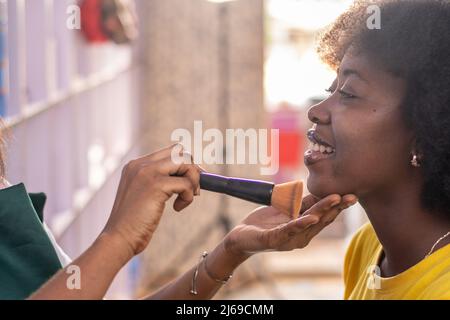 signora africana che fa il trucco per una signora Foto Stock