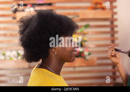 signora africana con afro in uno studio di trucco Foto Stock