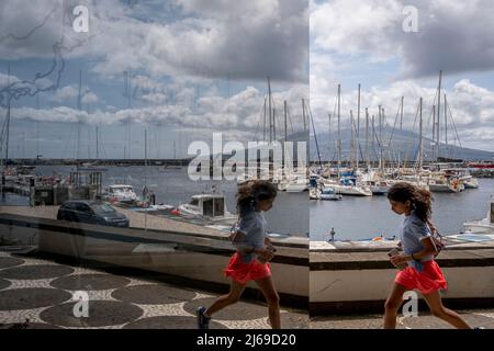 Faial, Portogallo - 07 Agosto 2021 : ragazza che corre vicino a uno specchio a Horta Foto Stock