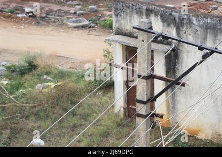 I cavi elettrici rurali trasportano l'elettricità su un palo di cemento all'aperto in una giornata di sole Foto Stock