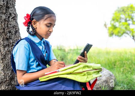 adolescente scuola ragazza capretto vicino agricolo farma ascoltare classe online - concetto di apprendimento a distanza, assistenza virtuale e istruzione. Foto Stock