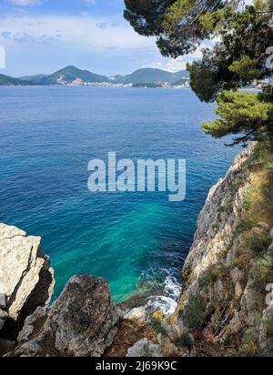 Roccia con acqua cristallina su una spiaggia di Sveti Stefan, Montenegro Foto Stock