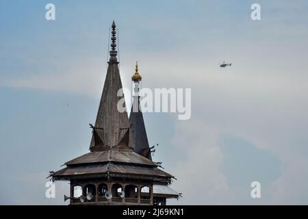 Srinagar, India. 29th Apr 2022. Un elicottero dell'esercito indiano sorvola la chiusa Grande Moschea storica (Jamia Masjid) durante l'ultimo venerdì di Ramadan a Srinagar. Le autorità nella valle del Kashmir hanno proibito le preghiere notturne e lo scorso venerdì delle preghiere congregazionali del Ramadan alla Grande Moschea (Jamia Masjid) a Srinagar. La decisione di non tenere le preghiere congregazionali è stata trasmessa al corpo di gestione della grande moschea il mercoledì sera. Credit: SOPA Images Limited/Alamy Live News Foto Stock