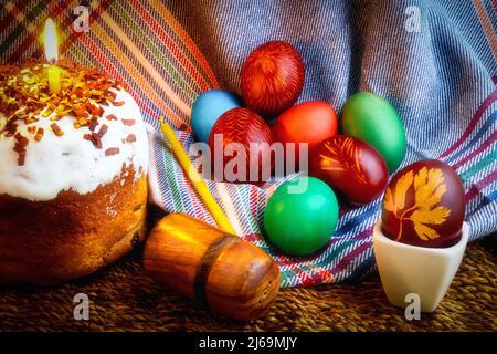 La festa di Pasqua, uova di gallina dipinte nei colori tradizionali, kulich, torta di festa, candele della chiesa. Foto Stock