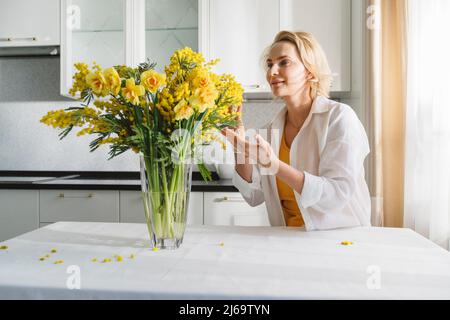 Una donna con un bouquet di fiori gialli di primavera. Foto Stock