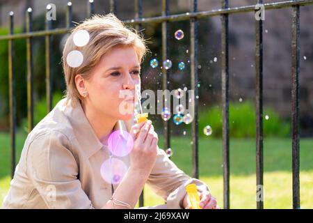 Il primo Ministro della Scozia Nicola Sturgeon soffia delle bolle durante una visita alla DrumChapel, Glasgow, mentre sulla campagna elettorale locale. Data foto: Venerdì 29 aprile 2022. Foto Stock