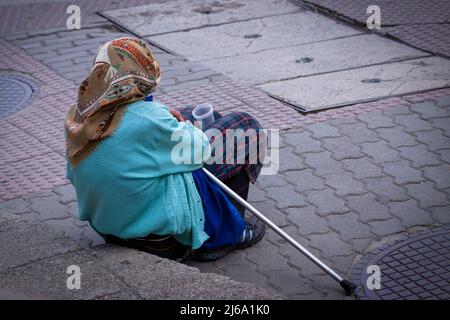 Donna anziana che implora per strada. Foto Stock