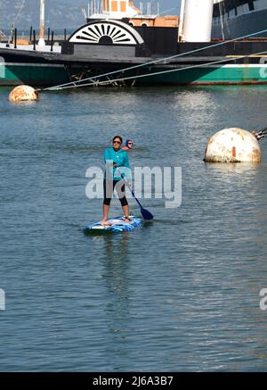 Una donna ama salire a bordo di un paddle board nella baia di San Francisco al largo del Fisherman's Wharf District di San Francisco, California. Foto Stock