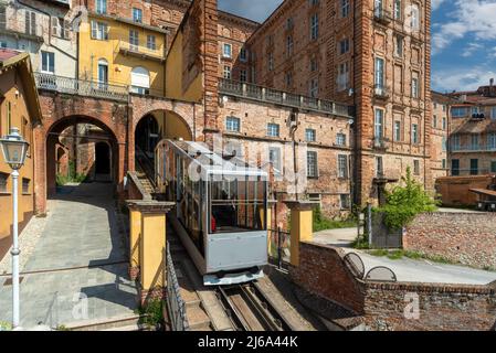 Mondovì, Italia - 29 aprile 2022: Funicolare arrivando alla stazione di vertice della Piazza del rione con edifici antichi, la funicolare collega la distr di Beo Foto Stock