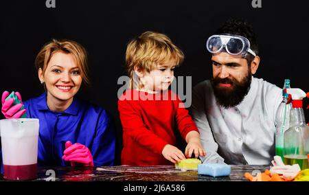 Madre e padre insegnano il figlio piccolo pulisce in casa. Famiglia pulito insieme. Giorno di pulizia. Foto Stock