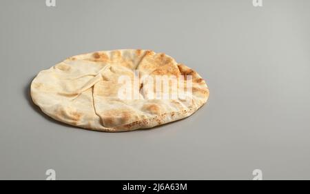 Tradizionale lavash di pane piatto su sfondo grigio, spazio per il testo, foto di scorta Foto Stock